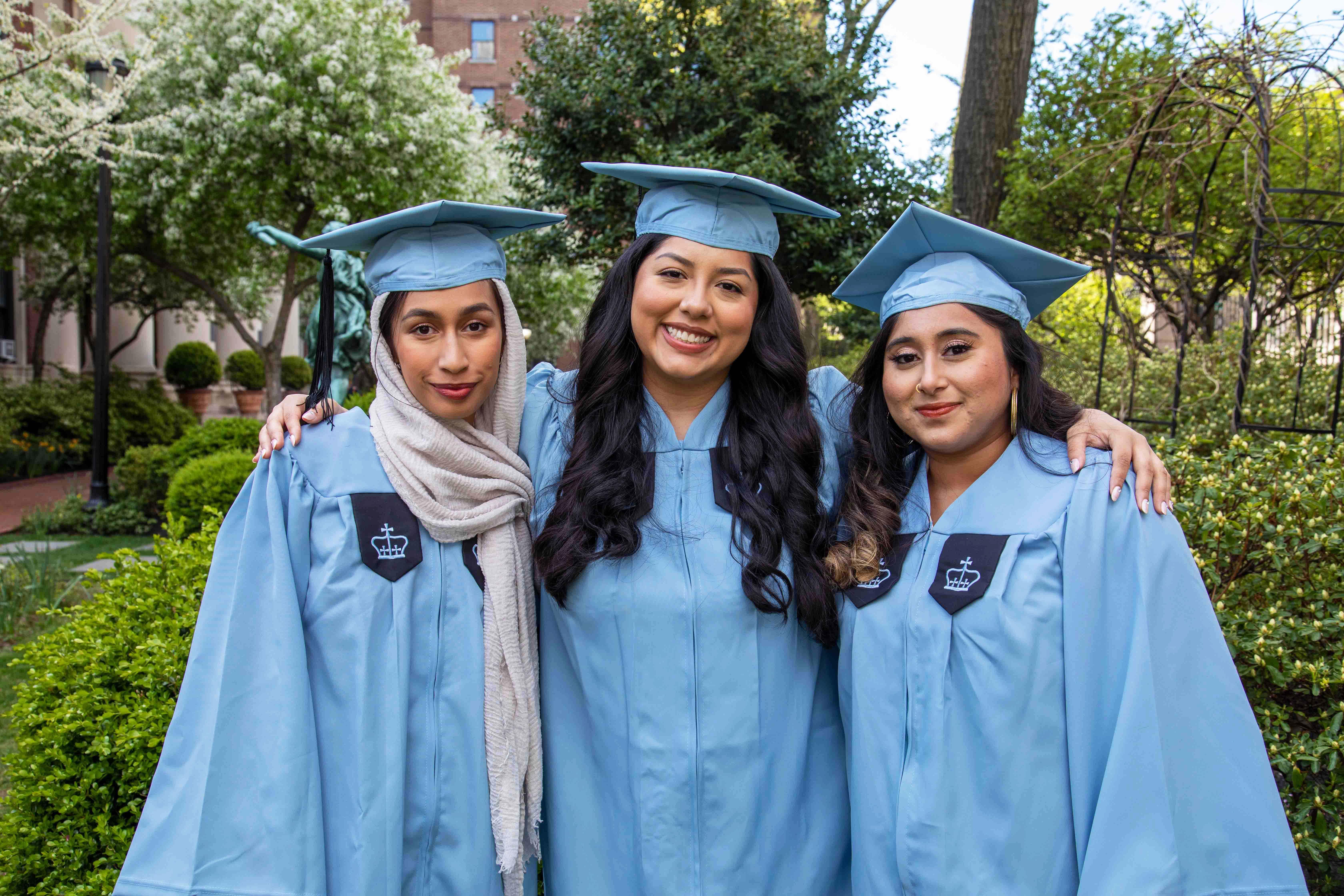  Samantha Bhuiyan, 22岁, Stephanie Secaira, 22岁, 和22岁的Amana Mohiuddin戴着帽子和礼服合影.